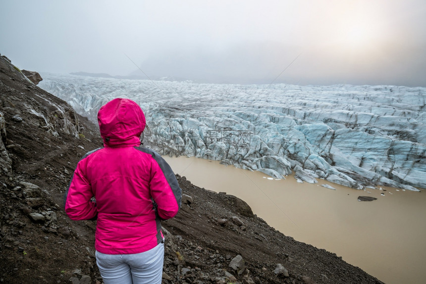女旅行者欣赏斯瓦纳霍库尔冰河湖美丽景色图片