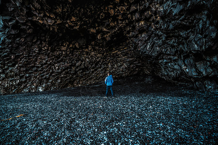 在火山黑岩洞穴的旅行爱好者图片