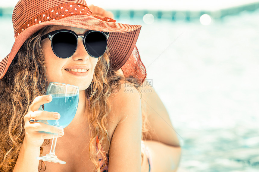 穿着泳衣的快乐年轻女子在豪华度假村游泳池玩得很开心图片