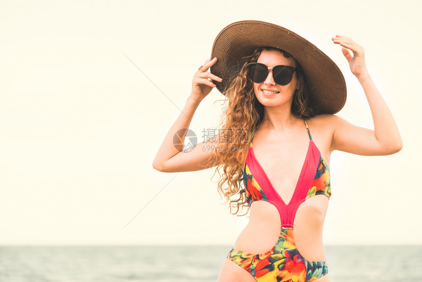 身穿泳衣的快乐年轻女子暑假在热带海滩度假图片