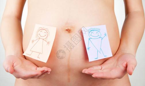 在孕妇腹部上贴有男女图标的纸贴爱高清图片素材