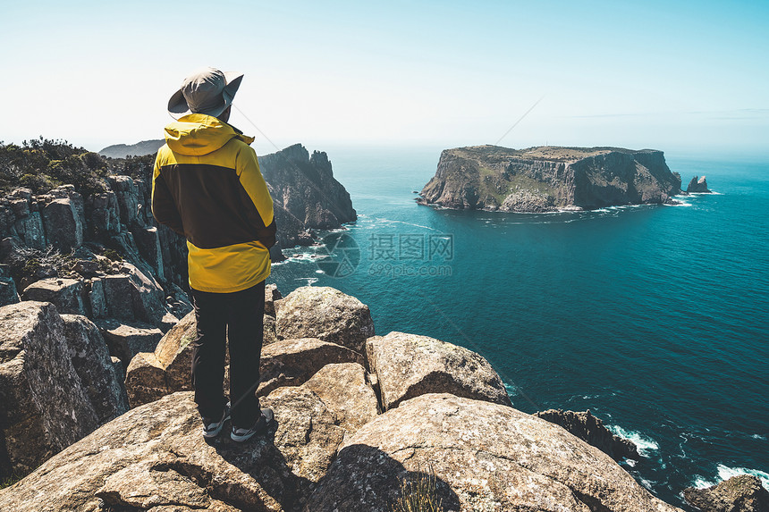 年轻人在塔斯曼半岛公园美丽的海岸悬崖上徒步旅行图片