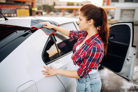 妇女洗完车后用布涤擦车肮脏的高清图片素材