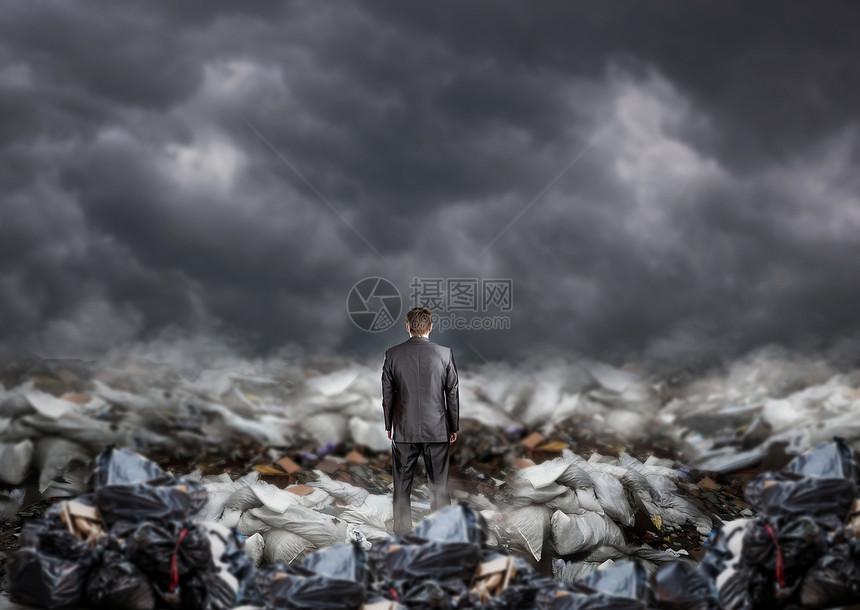 商人站在垃圾填埋场背视垃圾堆的中间环境商业和生态污染问题图片