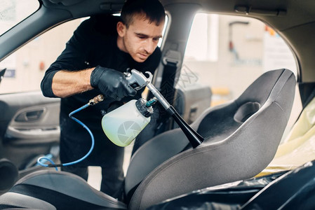 男洗车工对汽车内部进行冲洗清洁剂高清图片素材