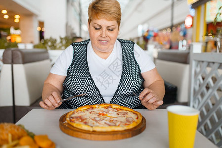 女人在快餐厅吃比萨图片