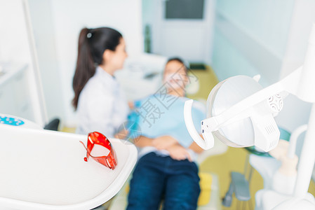 儿科牙医女牙医检查小病人的牙齿图片