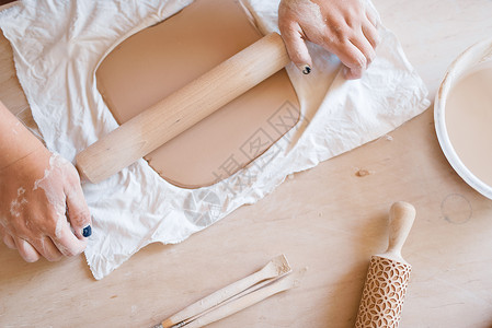 女陶工用擀面杖擀面杖陶艺作坊妇女成型工作材料手工陶瓷艺术粘土餐具图片