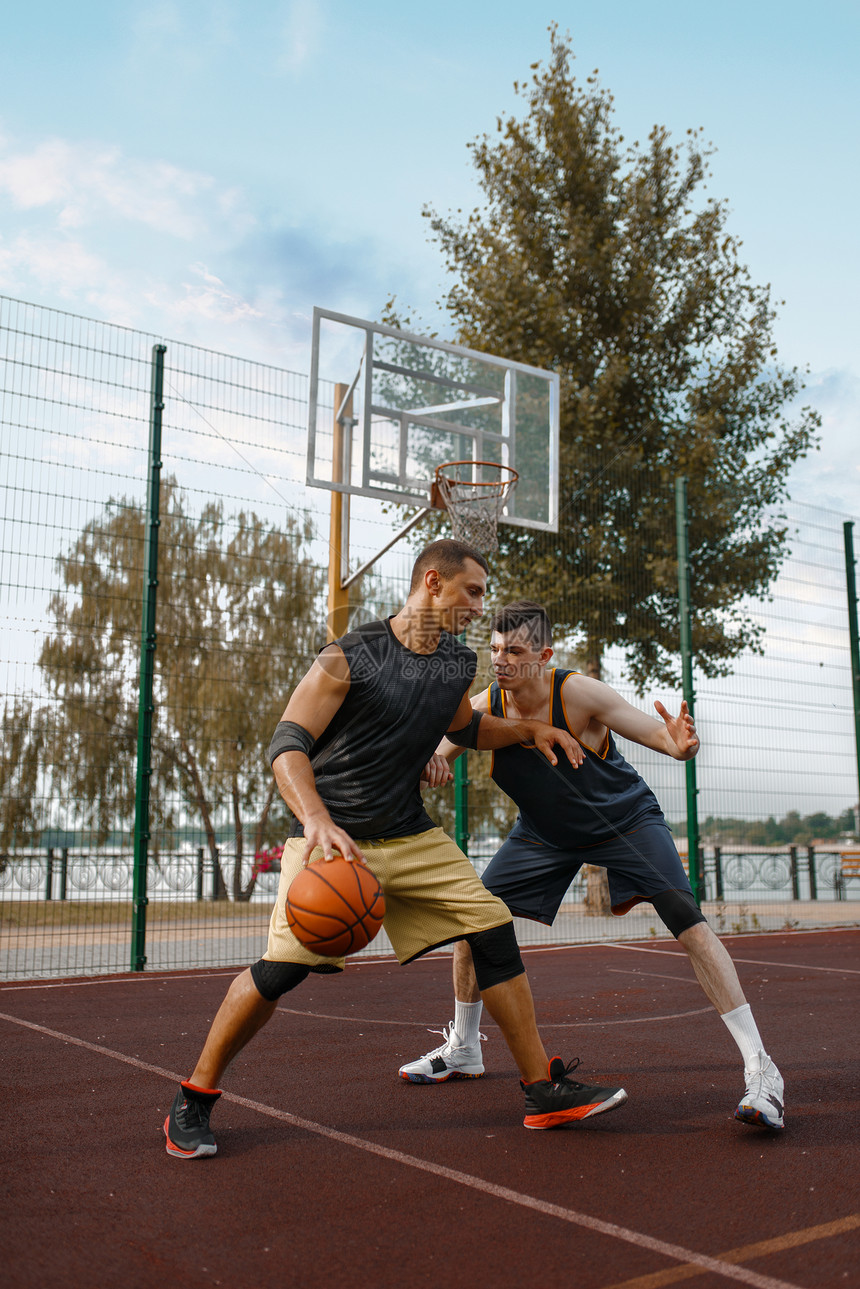 两名篮球运动员在室外球场上练习图片