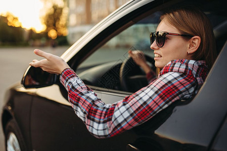 初学女司机戴着太阳镜微笑看向窗外开车高清图片素材