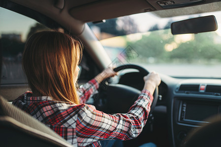 年轻的女司机正在驾驶汽车看后视镜许可证高清图片素材