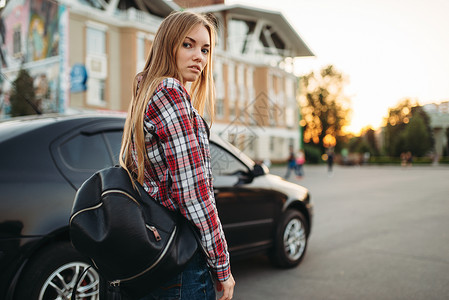 年轻女司机背着黑色包包靠在车旁交通高清图片素材