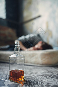 睡在床垫上的男人酗酒成瘾图片