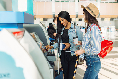 2名女旅行者在机场的Atm取现金图片