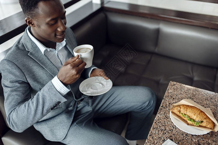 黑人商人在办公室喝咖啡吃午餐商业高清图片素材