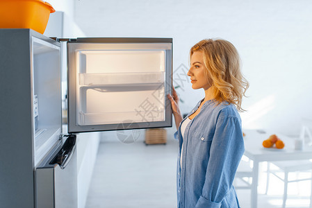 在厨房打开冰箱的女人图片