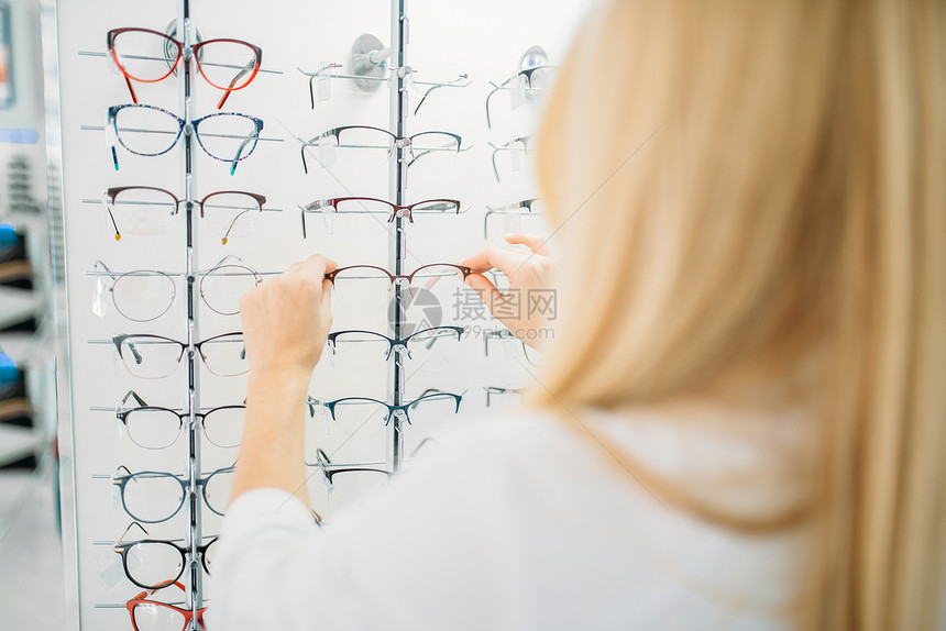 女士在眼镜店挑选眼镜图片