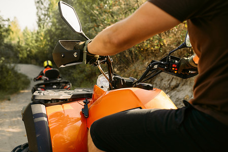 驾驶员在森林公路骑四轮摩托车危险的高清图片素材