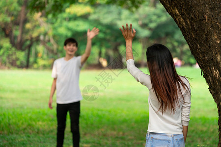 年轻男女公园里挥手打招呼图片