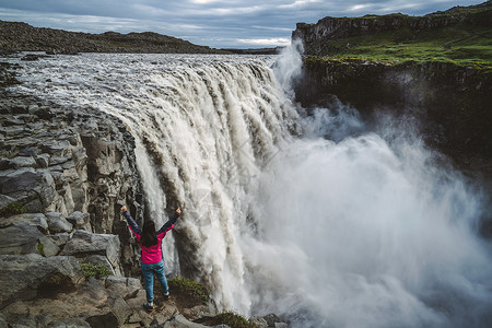 女游客被壮观的瀑布所震撼图片