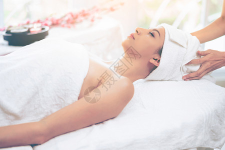 躺在温泉疗养床上进行芳香疗法按摩的放松妇女图片
