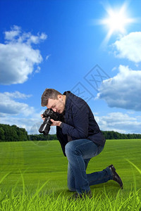 摄影师用相机拍摄草地图片
