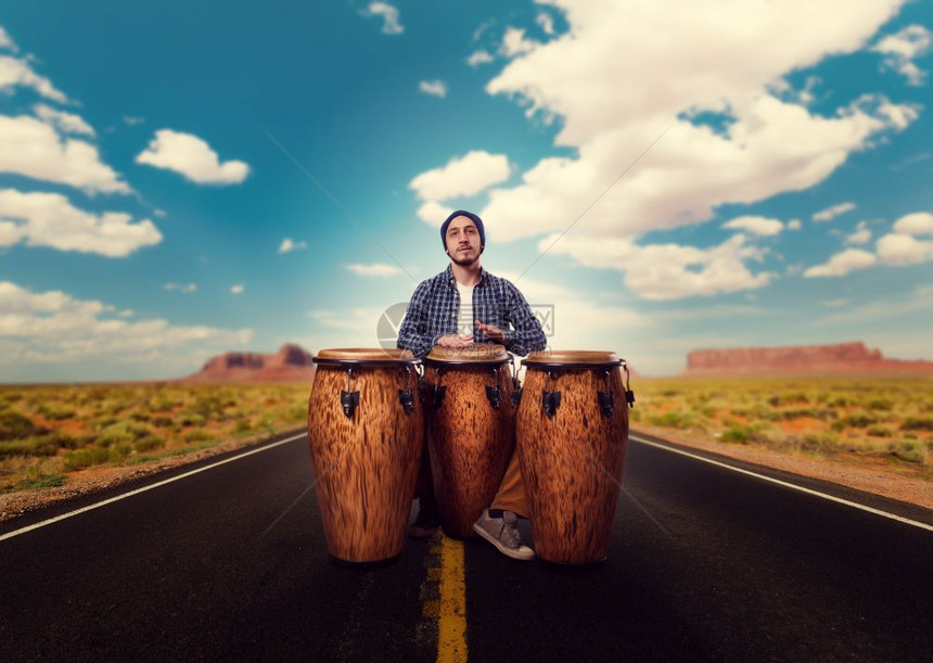 青年男子鼓手在沙漠路上玩木鼓音乐家在运动djemb音乐震荡器民族音乐图片