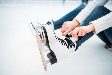 白色溜冰鞋冬天年轻人穿着溜冰鞋在户外滑冰绑鞋带背景