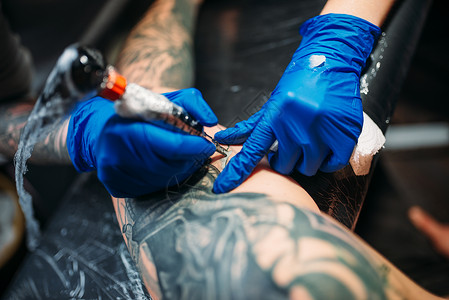 带纹身男女纹身师用机器在男肩上做纹身在沙龙专业纹身师用机器在男肩上做纹身背景