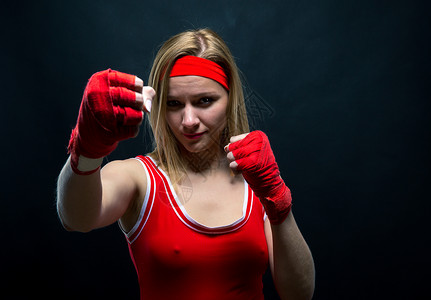 穿着红色拳击绷带和运动服训练的女拳击图片