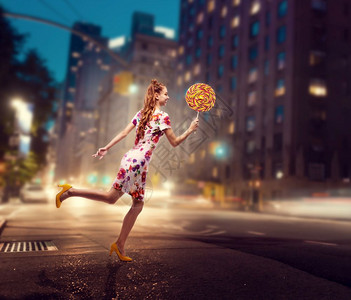 时髦的金色卷发女孩穿着多彩的夏天裙子夜市背景的时髦女孩图片