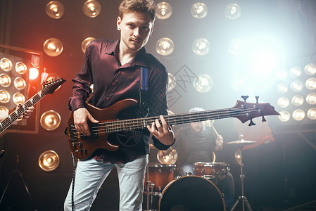 吉他手在bas摇滚乐队背景有灯光的舞台上演奏现场音乐会吉他手在bas摇滚乐队上演奏背景图片