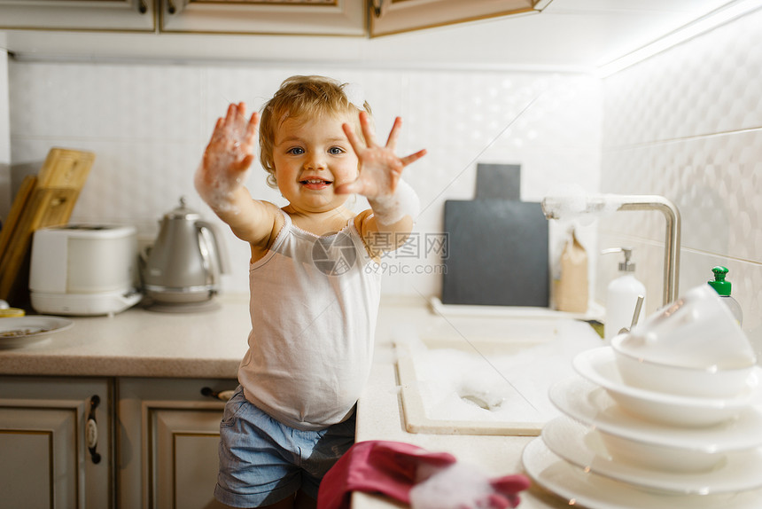 小女孩擦洗厨房的盘子图片