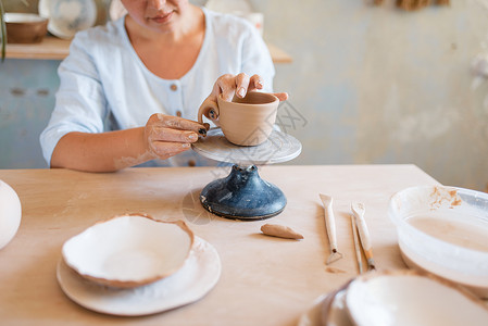 女陶瓷罐车间妇女制作碗手工陶瓷艺品用粘土制作的餐具女陶瓷炉车间图片