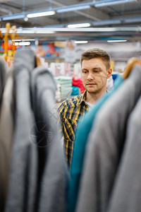 男人在服装商店挑选衣服图片