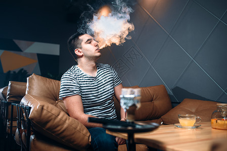 男人坐在沙发上吸烟背景图片