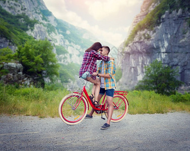 年轻男女一起在自行车上拥抱背景图片