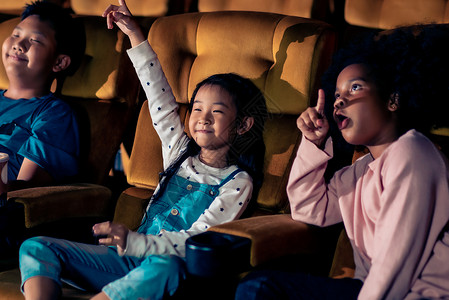 三个孩子玩得开心在电影院看电影幸福的高清图片素材