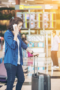 在国际机场使用电话的女游客图片