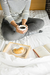 在床上看书吃早餐的女人图片
