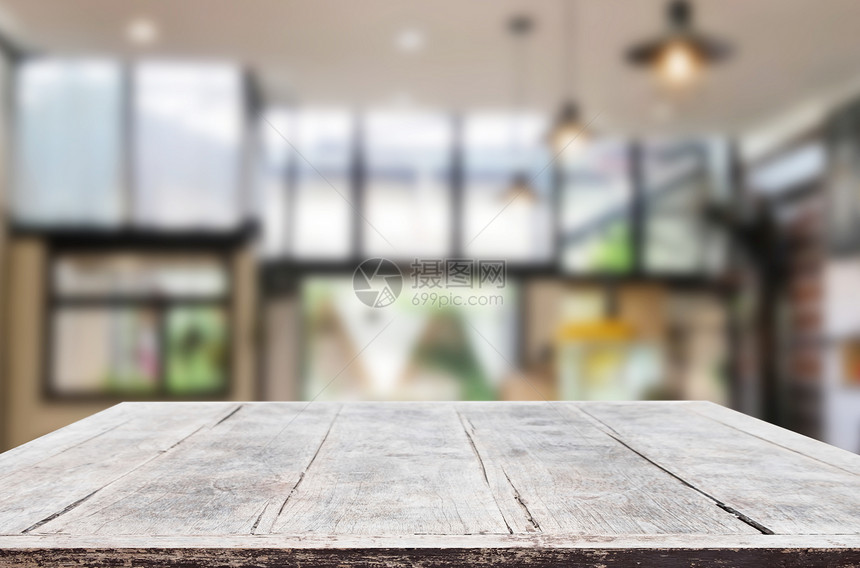 木板空桌和内部模糊的咖啡店背景图片