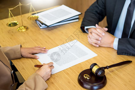 夫妻在婚姻金戒指结时遇到的问题法官裁决离婚签署文件或前协议向律师提供法咨询并安慰他的委托人背景图片