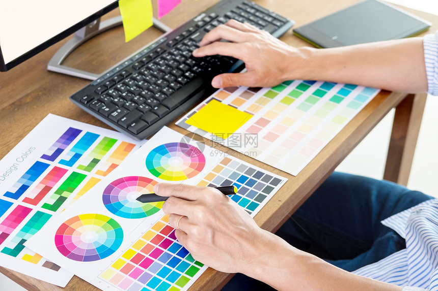 图形设计师或创造握住鼠标在办公室桌做他的工作材料彩色整肠观察样本艺术工具图片