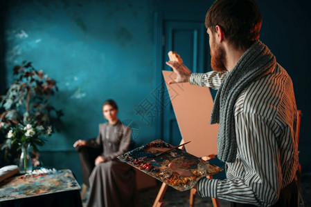 男画家手持调色盘和刷子在画女模特人高清图片素材