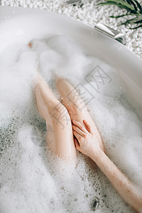 洗浴时用泡沫顶视放松卫生浴室皮肤护理温泉洗浴时用泡沫的女裸腿图片