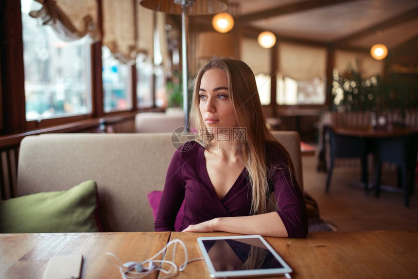 年轻女子坐在咖啡店目视远方图片