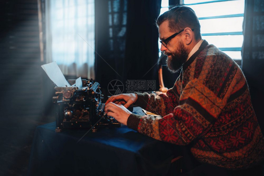 作家在古老的打字机上打字图片