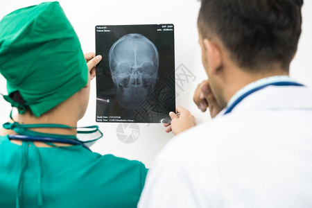 医生检查病人x光薄膜脑头骨图片