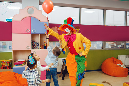 孩子们与小丑一起快乐的玩耍高清图片