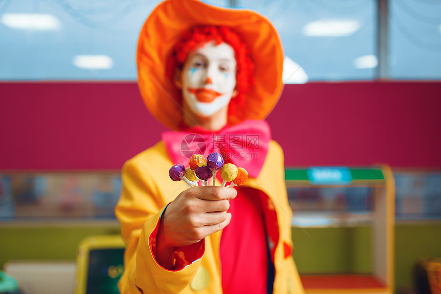 手持糖果的小丑在游戏室庆祝生日图片